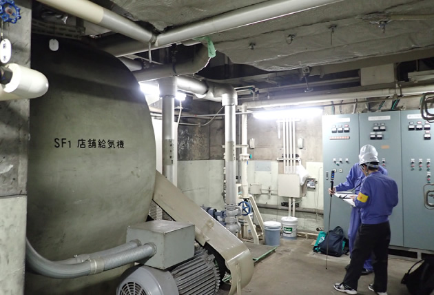 某地下街の熱源改修のため、既設状況を確認する様子